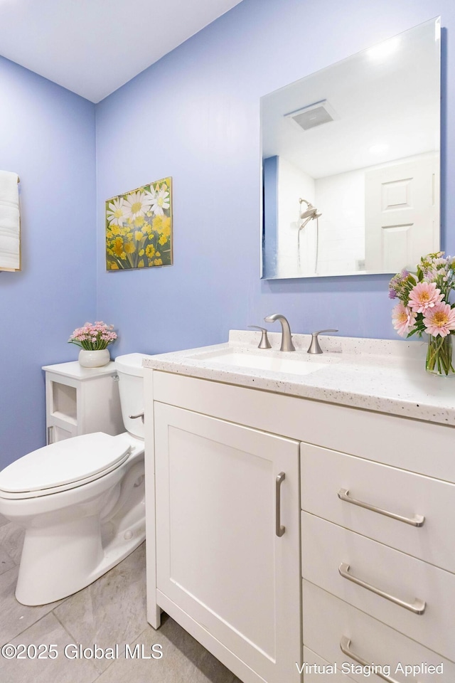 bathroom featuring visible vents, toilet, vanity, and tile patterned flooring