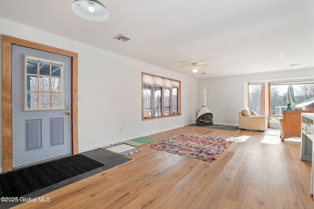 entryway featuring light wood finished floors, visible vents, baseboards, and a ceiling fan