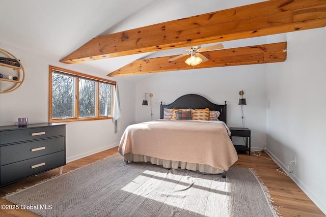 bedroom featuring lofted ceiling with beams, baseboards, and wood finished floors