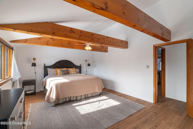 bedroom with vaulted ceiling with beams, baseboards, and wood finished floors