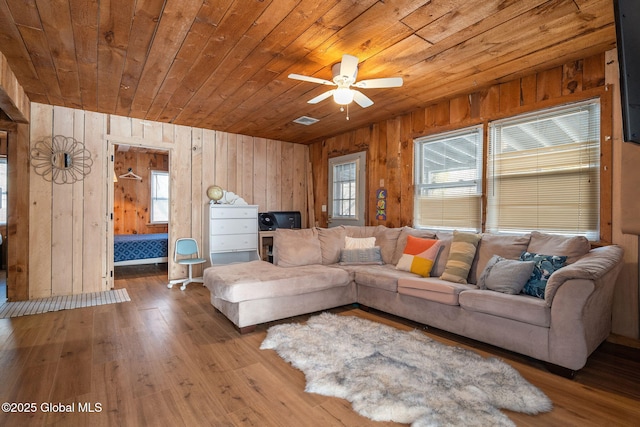 living room featuring wood ceiling, visible vents, wooden walls, and hardwood / wood-style floors