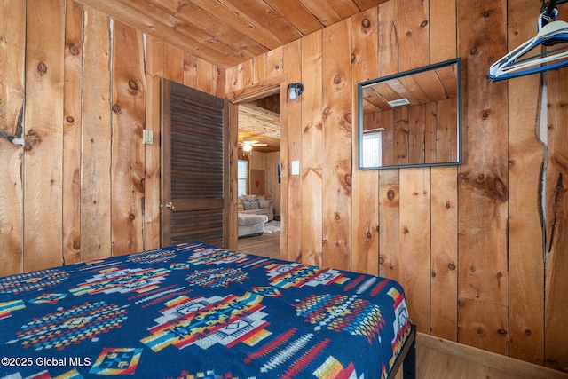 unfurnished bedroom with wood ceiling and wooden walls