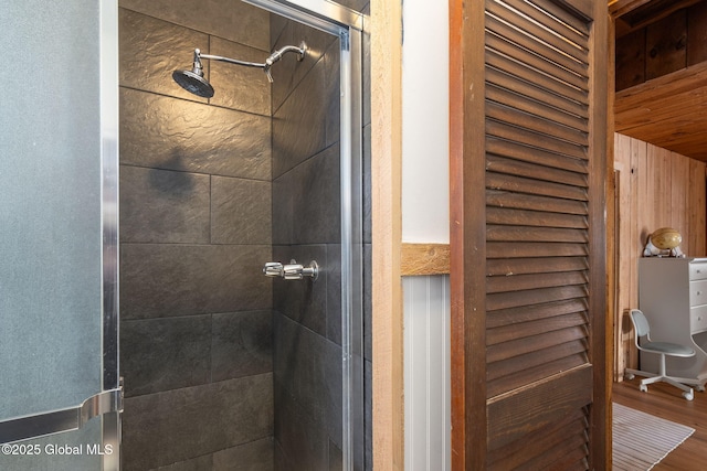 full bath featuring a stall shower and wood finished floors