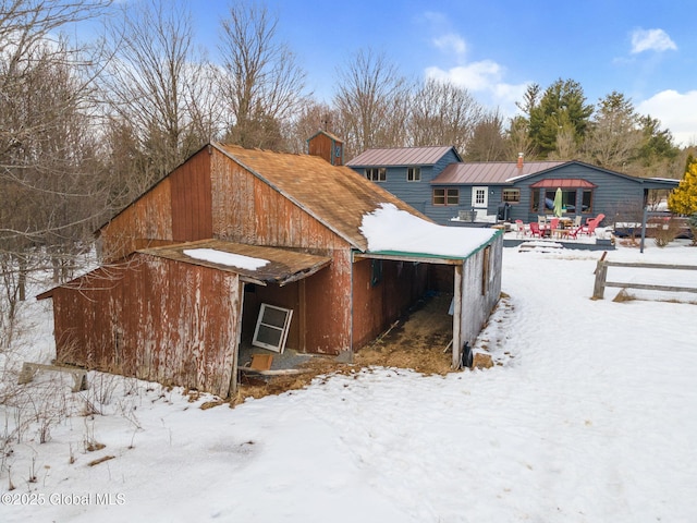 snow covered property featuring an outbuilding and a barn