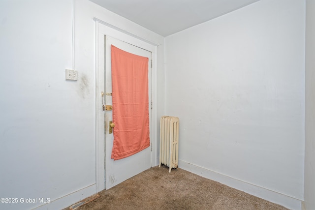 carpeted entrance foyer featuring radiator