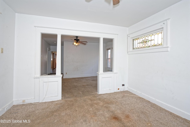 spare room featuring carpet, baseboards, and ceiling fan