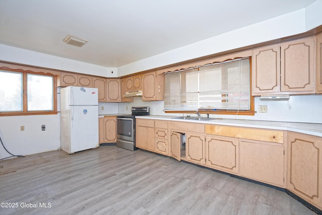 kitchen with under cabinet range hood, stainless steel electric stove, freestanding refrigerator, light wood-style floors, and light countertops