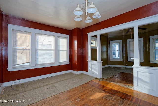 entrance foyer with baseboards, an inviting chandelier, and hardwood / wood-style floors