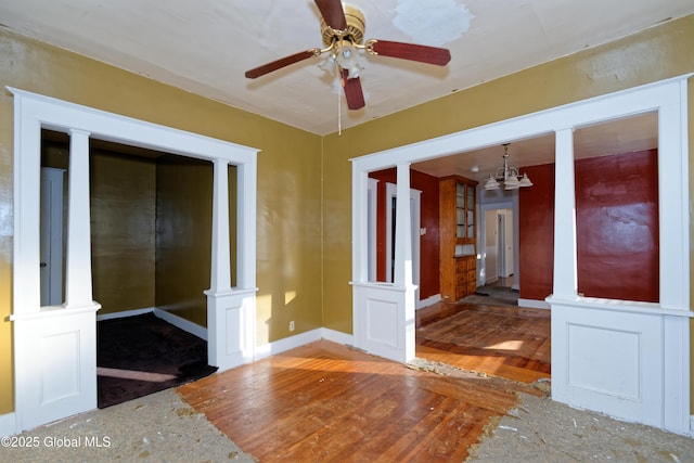 empty room with a ceiling fan, wood finished floors, and baseboards