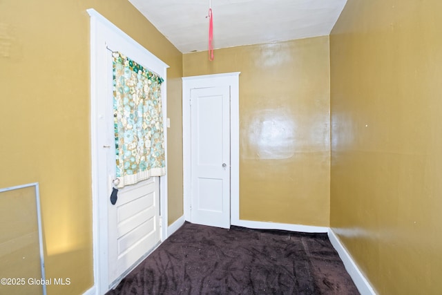 interior space with baseboards and carpet flooring