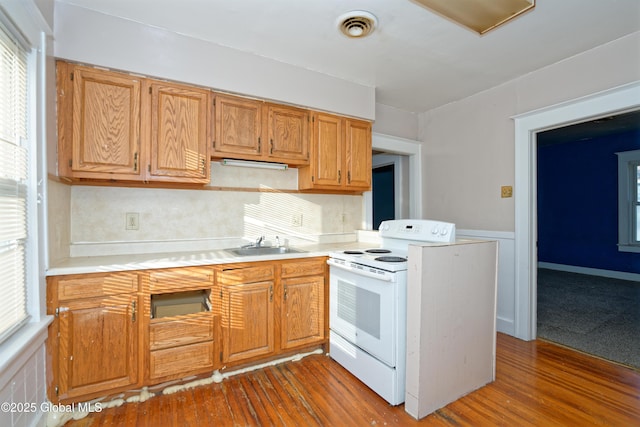 kitchen with a sink, light countertops, visible vents, and white electric stove