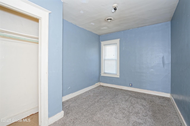 unfurnished bedroom featuring baseboards, visible vents, and carpet floors