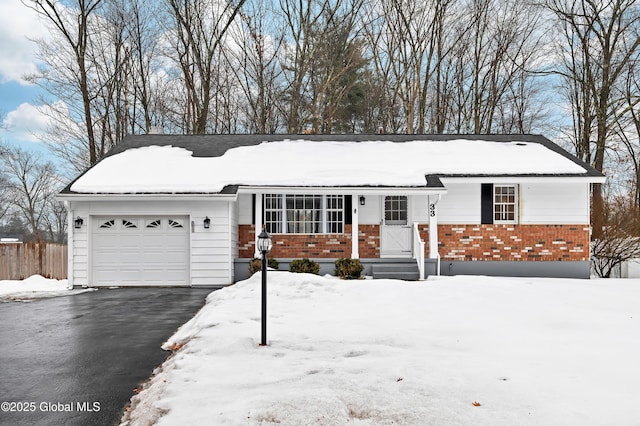 ranch-style home featuring a garage, driveway, brick siding, and a porch