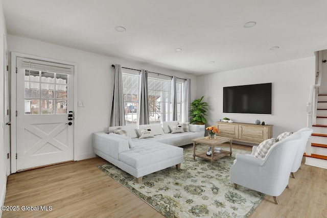 living room with light wood-style floors and stairs