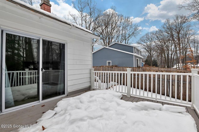 snow covered deck featuring fence