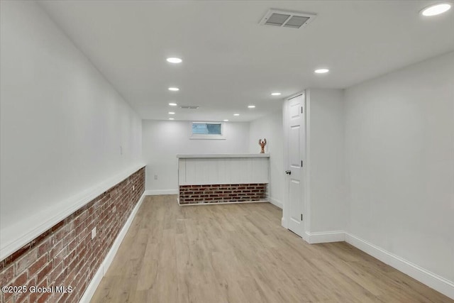 interior space with recessed lighting, visible vents, brick wall, and wood finished floors