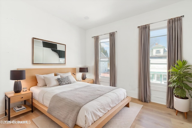 bedroom with light wood-style floors and baseboards