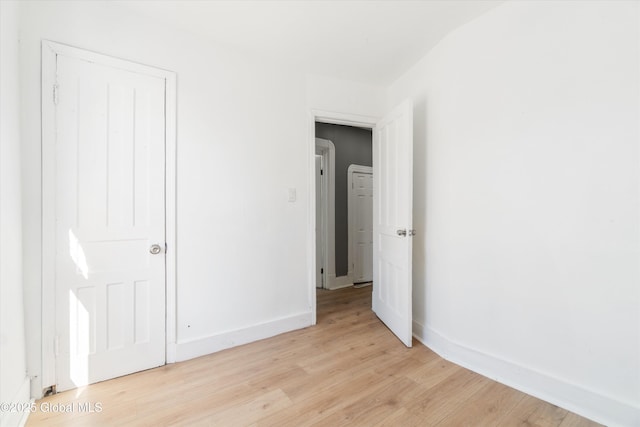 unfurnished bedroom featuring light wood-type flooring and baseboards