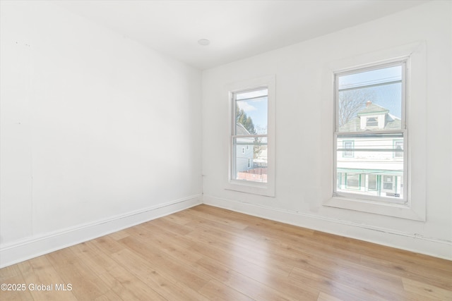 unfurnished room with baseboards and light wood-style floors