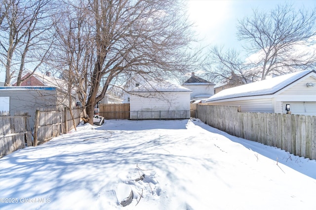 yard covered in snow featuring fence