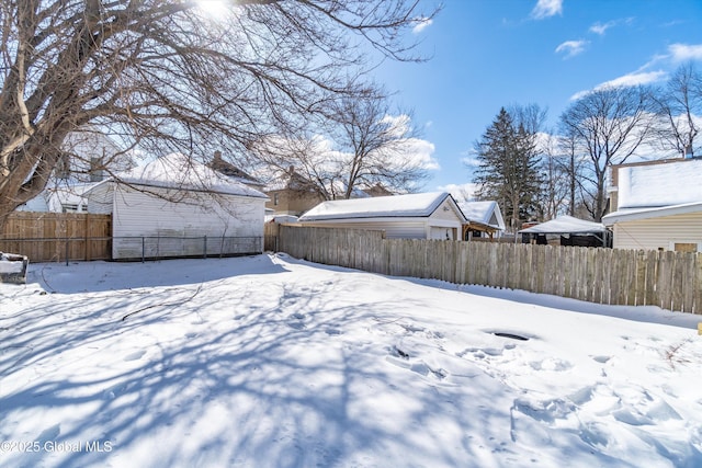 snowy yard featuring fence