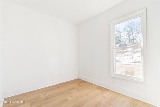 spare room with light wood finished floors and baseboards