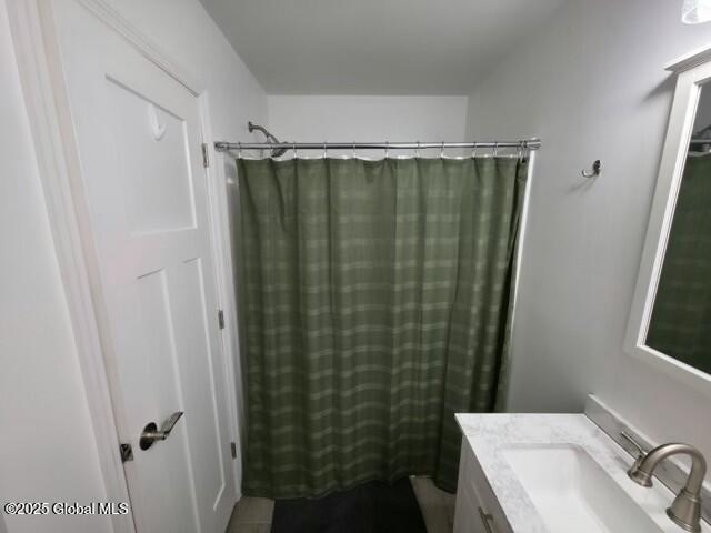 bathroom with curtained shower and vanity