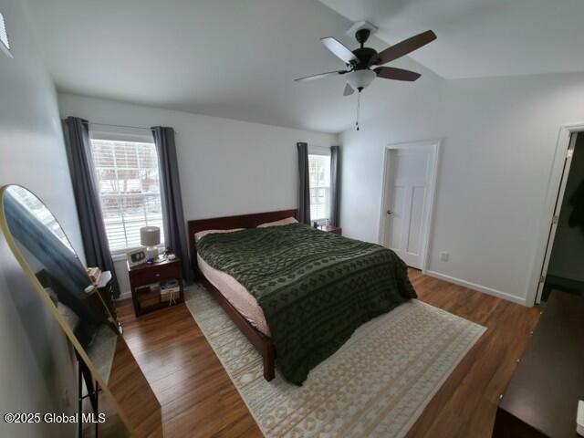 bedroom featuring lofted ceiling, ceiling fan, baseboards, and wood finished floors