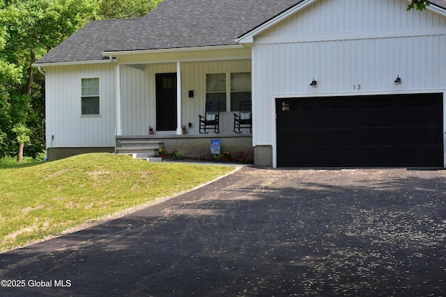 32 Swan St, Kingsbury, NY 12839 - view of front of house featuring roof with shingles, covered porch, a front lawn, and a garage