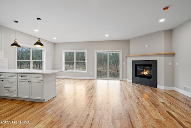 706 Swaggertown Rd, Charlton, NY 12302 - unfurnished living room featuring light wood finished floors, a glass covered fireplace, baseboards, and recessed lighting