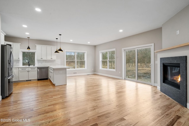 706 Swaggertown Rd, Charlton, NY 12302 - unfurnished living room with light wood-style floors, recessed lighting, a glass covered fireplace, and baseboards