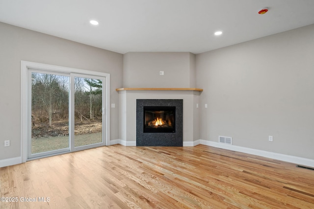 706 Swaggertown Rd, Charlton, NY 12302 - unfurnished living room featuring a glass covered fireplace, wood finished floors, recessed lighting, and baseboards