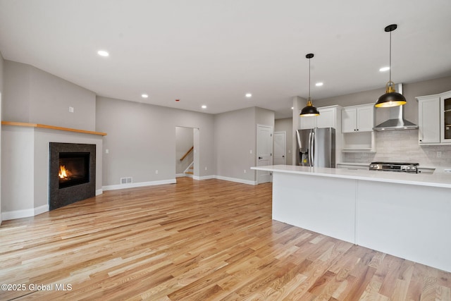 706 Swaggertown Rd, Charlton, NY 12302 - kitchen featuring stainless steel refrigerator with ice dispenser, light wood finished floors, light countertops, white cabinets, and tasteful backsplash