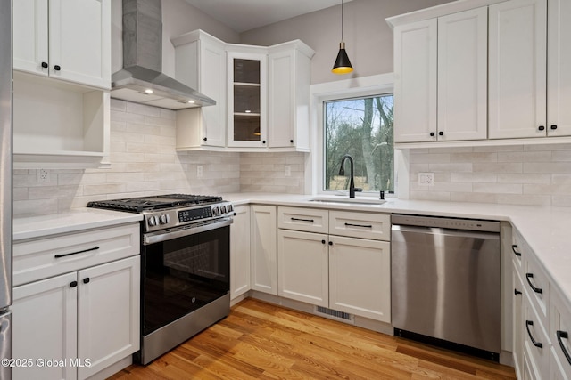 706 Swaggertown Rd, Charlton, NY 12302 - kitchen featuring appliances with stainless steel finishes, wall chimney exhaust hood, a sink, white cabinets, and light countertops