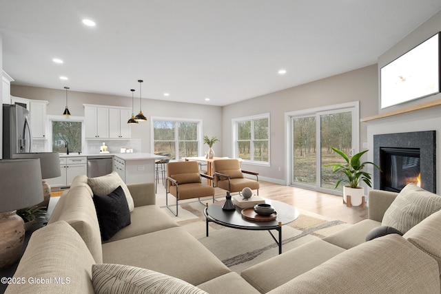 706 Swaggertown Rd, Charlton, NY 12302 - living room featuring light wood-type flooring, recessed lighting, a glass covered fireplace, and baseboards
