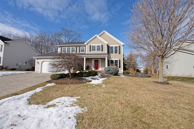 view of front of house with a front yard, decorative driveway, and an attached garage