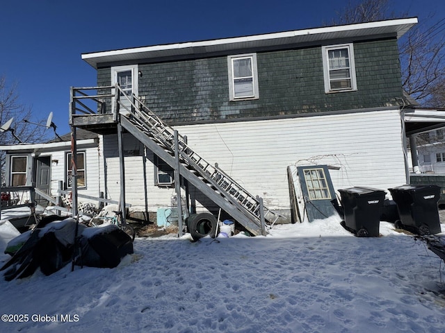 snow covered property featuring stairs