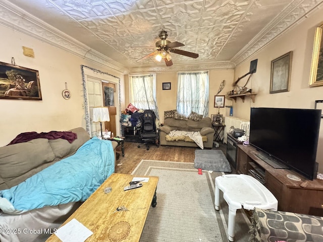 interior space featuring ceiling fan, ornamental molding, wood finished floors, and an ornate ceiling