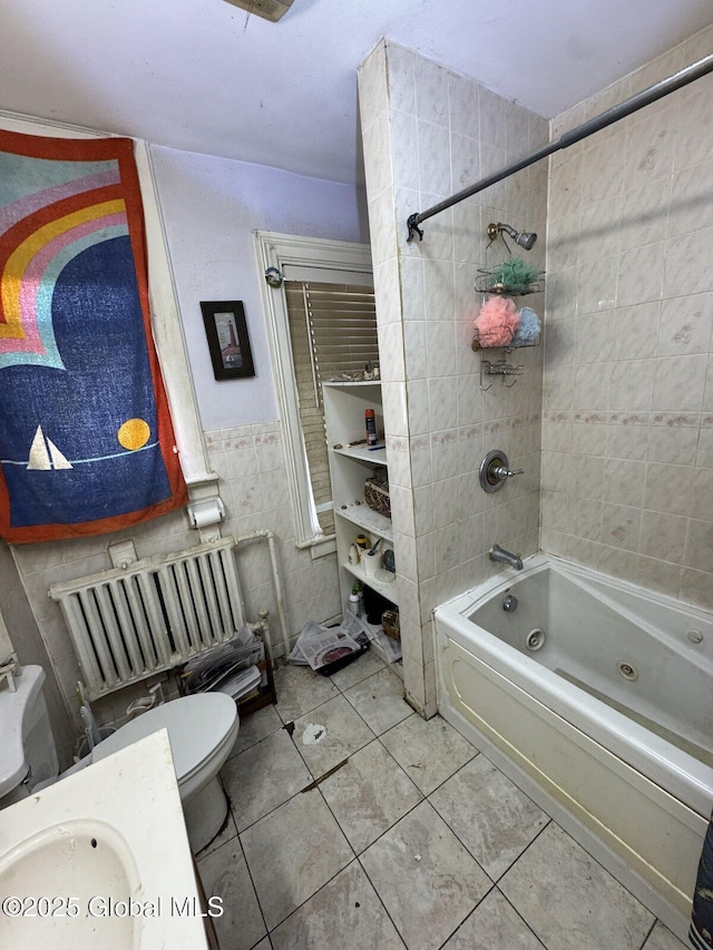 bathroom featuring toilet, tile patterned flooring, washtub / shower combination, and tile walls