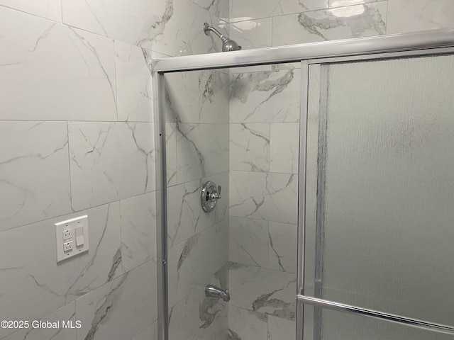 bathroom with a shower with door