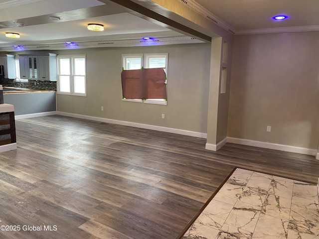 unfurnished living room with ornamental molding, dark wood-style flooring, and baseboards