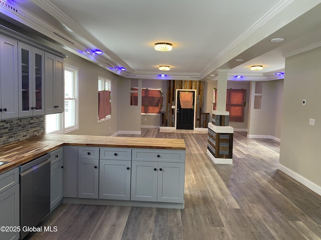 kitchen featuring gray cabinetry, wooden counters, dishwasher, a tray ceiling, and glass insert cabinets