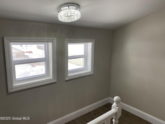 stairs with a wealth of natural light, baseboards, and wood finished floors