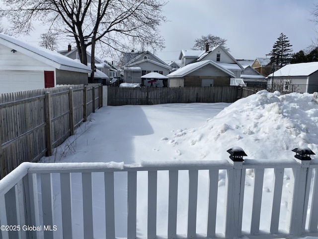 yard covered in snow featuring a fenced backyard