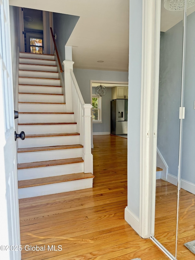 stairway featuring wood finished floors and baseboards