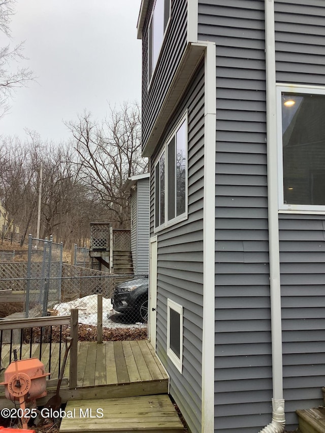 view of home's exterior featuring a wooden deck and fence