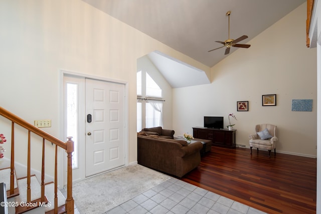 entryway featuring high vaulted ceiling, a ceiling fan, light tile patterned floors, and stairs