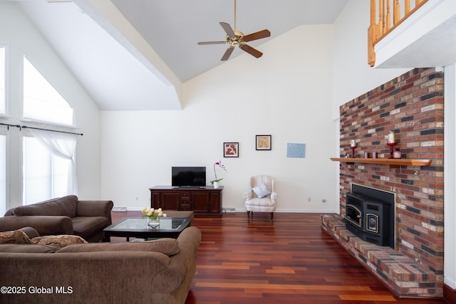 living area with high vaulted ceiling, dark wood-type flooring, a ceiling fan, and baseboards