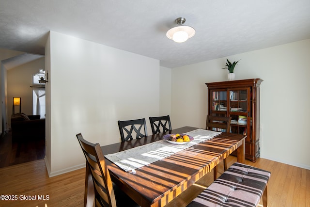 dining area featuring light wood-style flooring and baseboards