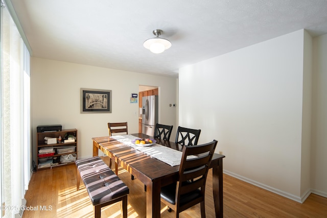 dining area with baseboards and wood finished floors